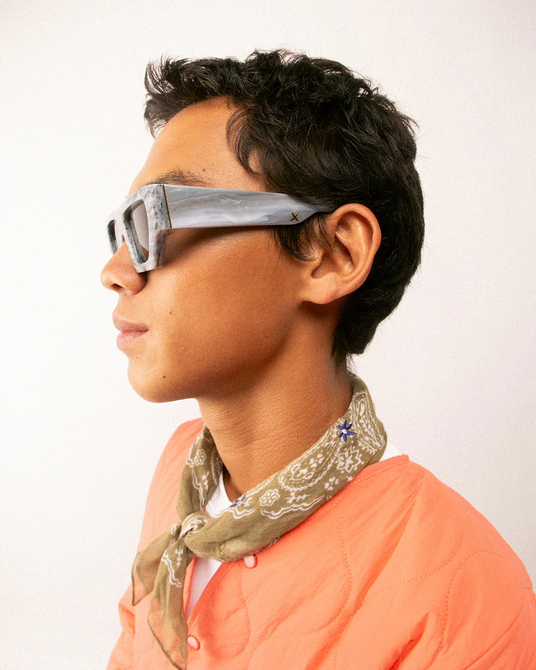 Person wearing futuristic sunglasses by Oscar Frank with a plain background