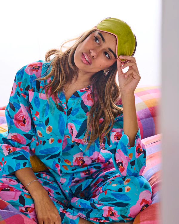 Model wearing the Morning harvest organic cotton long sleeve shirt & pant pyjama set by Kip & Co - red, pink and blue floral pattern