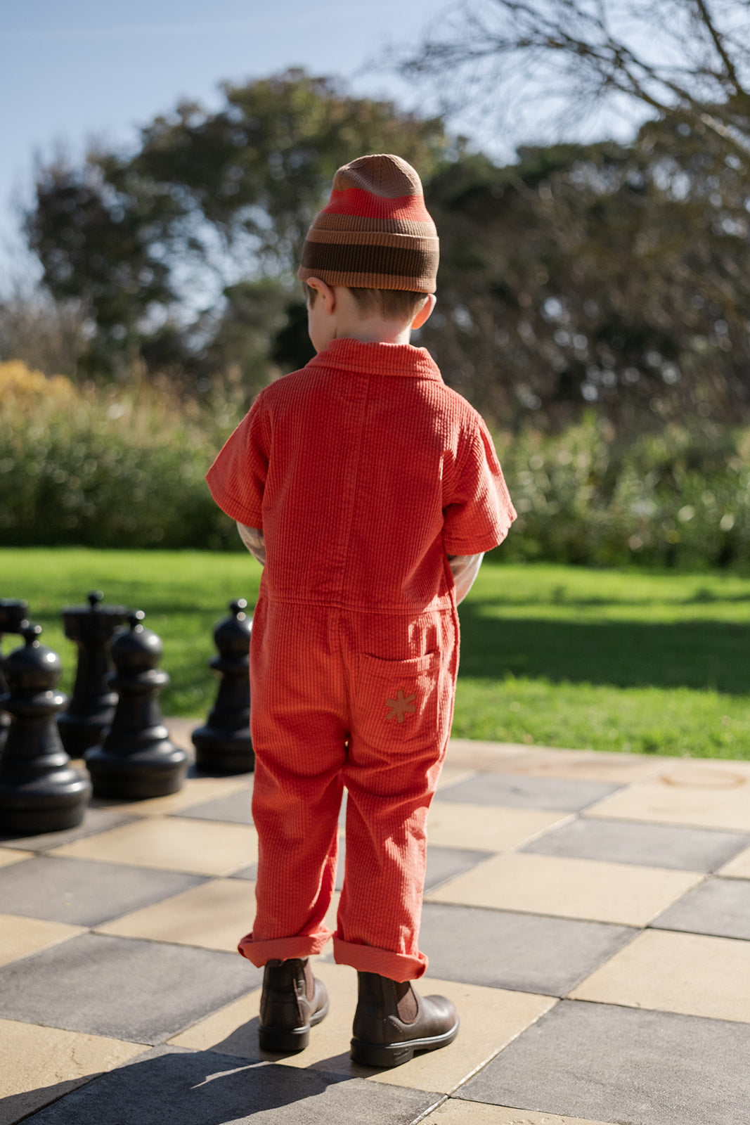Back view of young boy in the Organic Striped Pixie Knit Beanie - Earth | Grown Clothing