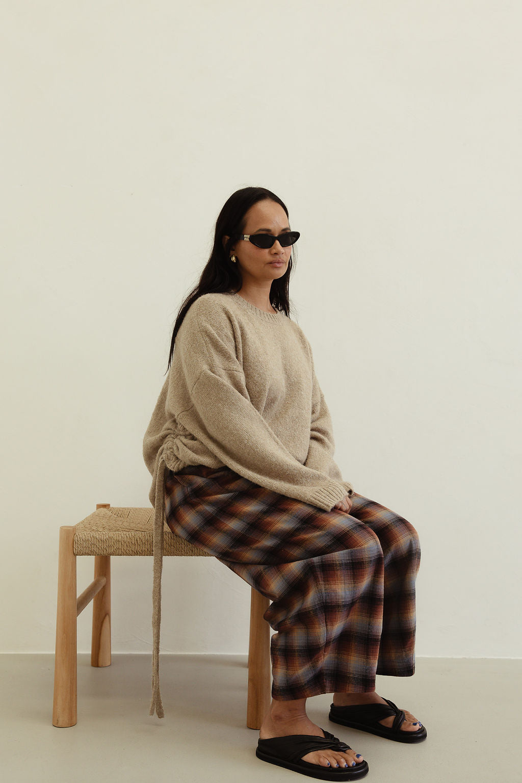 Side seated angle of Vali check pants showcasing brown blue plaid print and relaxed fit