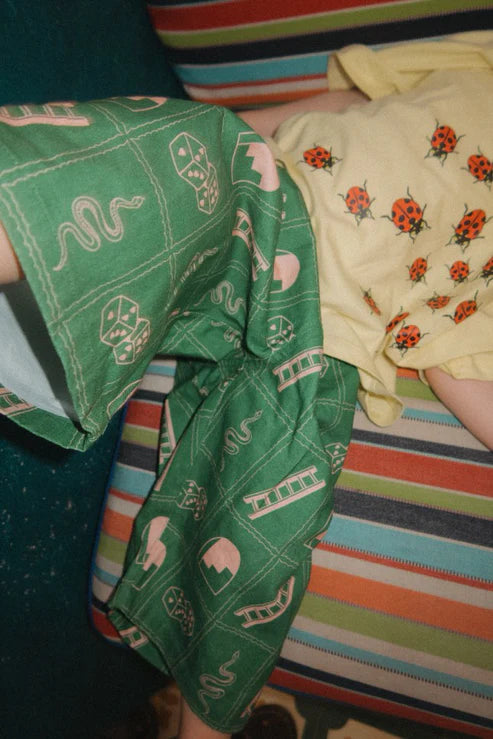 Child wearing the green snakes and ladder pants by Sauce Mini