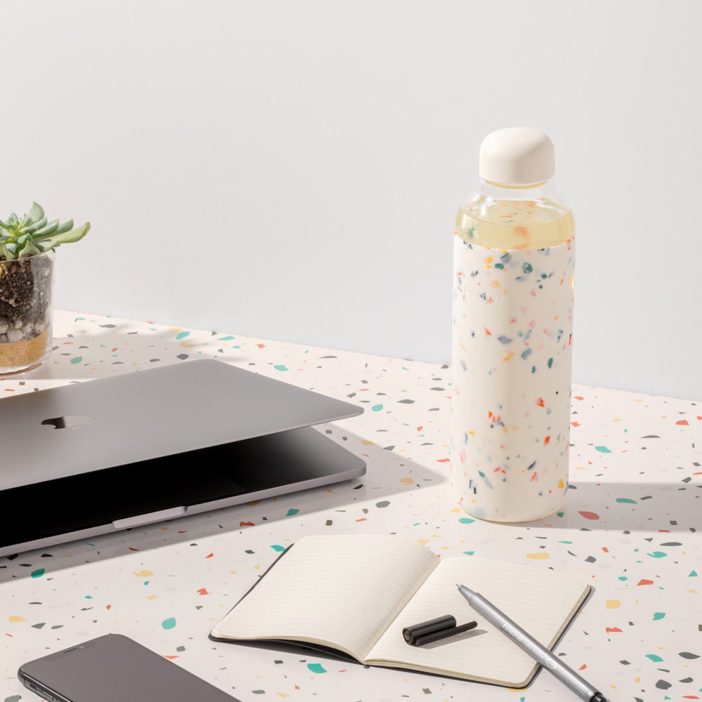 glass water bottle in white by porter. lifestyle image