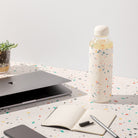 glass water bottle in white by porter. lifestyle image